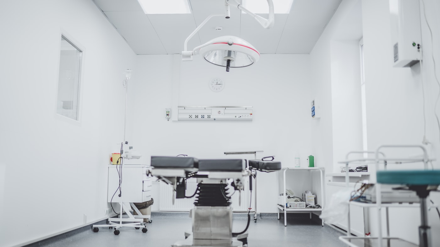 A modern clinical room with surgical lighting and equipment, empty